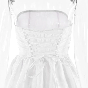 Detail view of white jacquard dress featuring an elegant backless lace-up ribbon design