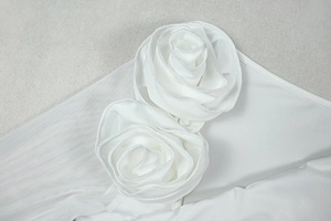 Close-up of the white 3D floral rose applique on the slim fit asymmetric dress