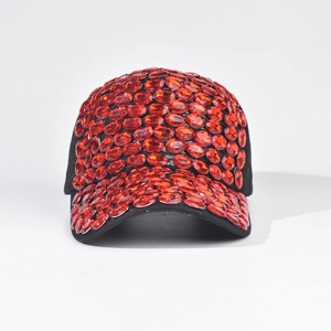Dettaglio di strass ovali rossi incastonati su un cappello da baseball nero