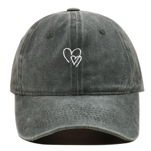 Dettaglio del ricamo a cuore bianco su un cappellino in cotone lavato grigio scuro