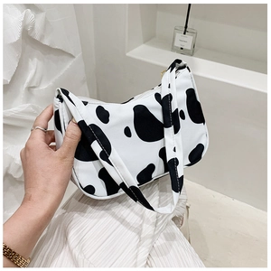 Detail of cow print hobo bag with zipper closure and black and white pattern