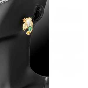Detailed view of fish tail earring with opal and colorful gemstones in golden finish