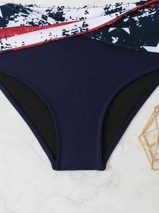 Detail of high-waist bikini bottoms with navy blue fabric and American flag print trim