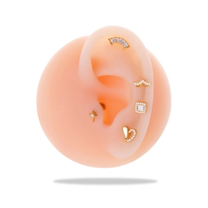 Detail of G23 titanium gold heart and star earrings on a silicone ear model
