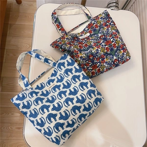 Detail of blue abstract cat and vintage floral prints on cotton canvas tote bags