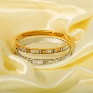 Bracelets en acier doré et argenté avec zircons et cœur sur fond de soie