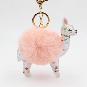 Detail of pink faux fur pompom and white leather alpaca pendant with golden keychain