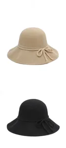 Detailed view of beige and black knit sun hats with elegant decorative bow ties