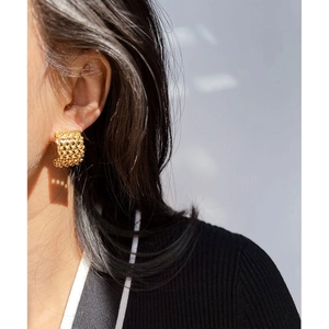 Boucle d'oreille vintage en forme de cœur doré avec texture grainée sur un mannequin