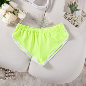 Detail der neongrünen Sportshorts mit weißem Saum und elastischem Bund in Flachlage