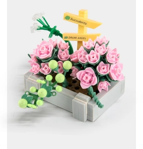 Macro detail of succulent building blocks with pink roses and grey planter base