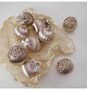Detail of champagne gold Christmas balls with silk texture, sequins, and white bows