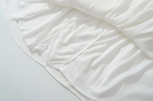 Detalle de tela de gasa blanca con pliegues delicados y textura suave
