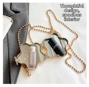 Détail du sac miroir en métal doré en forme de fleur avec chaîne et miroirs doubles