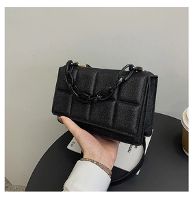 Détail du sac bandoulière noir matelassé avec poignée en chaîne épaisse et fini pailleté