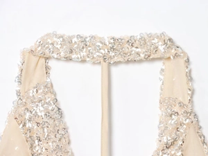 Gros plan sur tissu mesh champagne avec sequins argentés et texture métallique fine