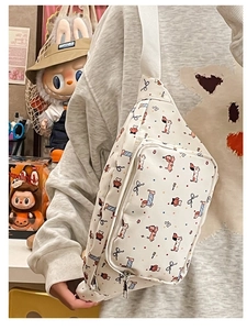 Detail of cute cartoon dog print on a cream crossbody bag with a white strap zipper