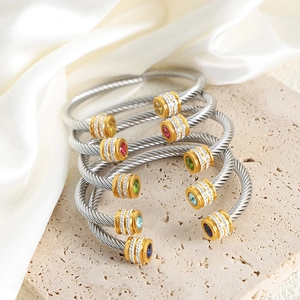 Cable style open cuff bracelet with colorful zircons on silk and travertine background