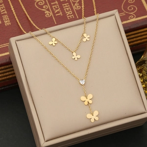 Detail of a double-layer gold butterfly necklace with a heart zircon pendant on a box