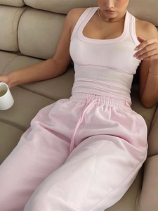 Pink women sports lounge set with ribbed tank top and drawstring joggers on sofa