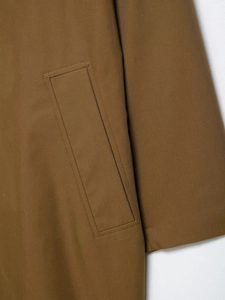 Detail of reinforced rectangular pocket stitching on khaki brown twill trench coat
