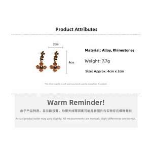 Detailed view of amber rhinestone cross earrings with alloy frame and silver needles