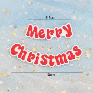 Macro detail of red Merry Christmas soft rubber cake toppers with size measurements