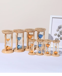 Close-up of bamboo hourglasses with blue and orange fine sand on a white surface
