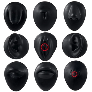 Black silicone anatomical body piercing training models set on white background
