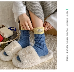 Close-up of ribbed knit wool socks in blue and yellow with 'Something Better' label