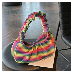Detail of colorful rainbow gradient pleated handbag with silky satin fabric texture