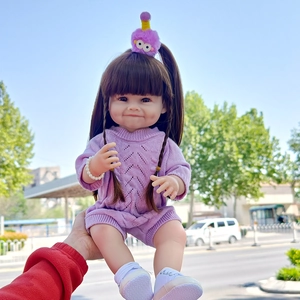 Detail of 55cm realistic reborn doll wearing purple knit romper and pearl bracelet