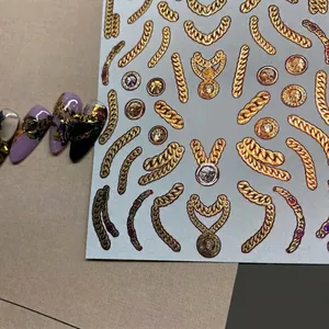 Stickers ongles style métal vintage avec chaînes dorées et textures de pièces