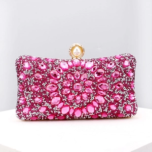 Macro detail of rose pink evening clutch with floral crystals and large pearl clasp