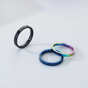 Detailed close-up of 3mm minimalist polished steel rings in black, blue and rainbow finish