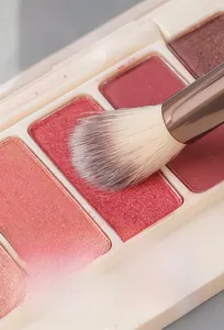 Detailed macro view of soft brush bristles picking up pink powder eyeshadow