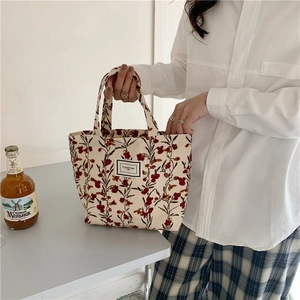 Detail of vintage floral corduroy lunch bag with Pleasant Time woven label in hand