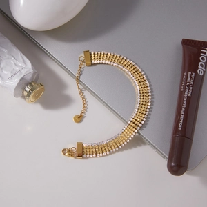 Dettaglio di un bracciale tennis dorato a cinque file con zirconi e chiusura a moschettone