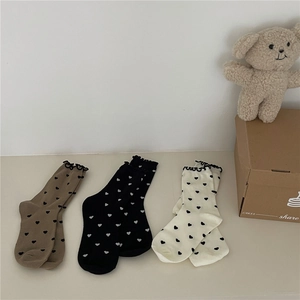 Three pairs of knit crew socks with heart patterns and ruffle cuffs in neutral tones
