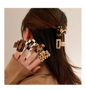 Close-up of leopard and checkerboard acetate hair clips styled in a model's hair