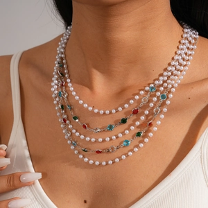 Detail of layered baroque pearl necklace with colorful gemstones on a silver chain