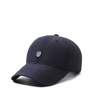 Detail of navy blue baseball cap with H-logo and breathable quick-dry fabric texture