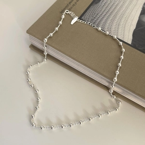 Minimalist 925 sterling silver ball chain necklace on a vintage book background