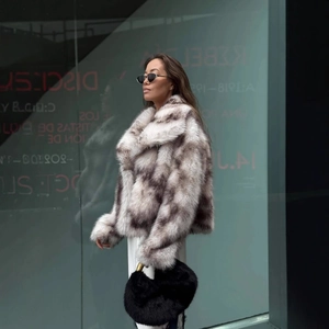 Fashionable faux fur short coat in gray-brown mix with white trousers for outdoor streetwear