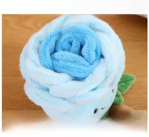 Close-up of blue plush rose flower with cute smiling face on a wooden background