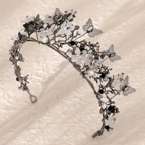 Detailed macro view of Gothic black branch crown with metal butterflies and white pearls