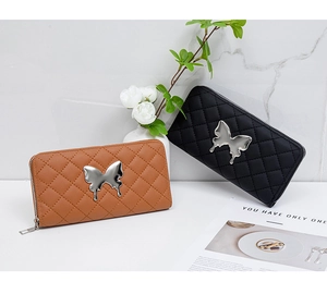 Detail of embroidered quilted clutches with butterfly charms in black and brown