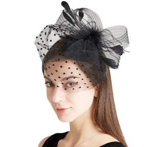 Detail of a vintage black bridal fascinator with mesh veil, feathers, and polka dots