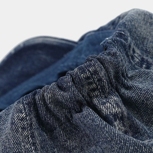 Detailed macro view of the elastic denim waist and washed fabric texture on a cap
