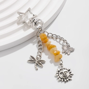 Silver metal keychain with yellow stones featuring star, dragonfly and sun pendants